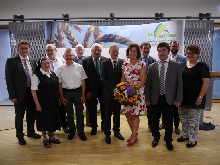 Gruppenfoto - In der Mitte eine Dame mit einem Blumenstrauß in der Hand